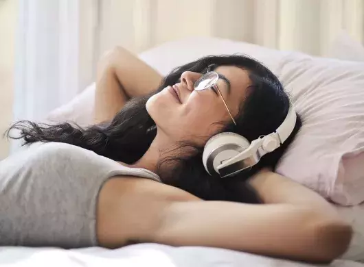 Joven acostada escuchando música