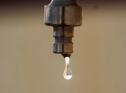 Gota de agua cayendo de una llave