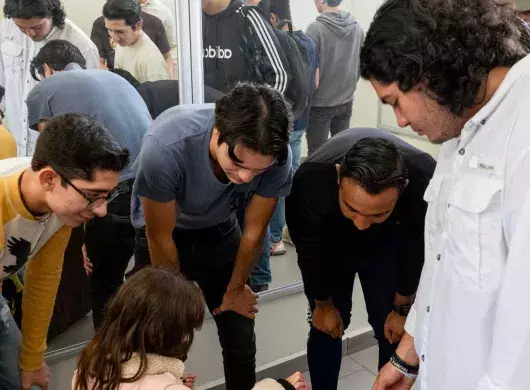 Estudiantes entregando silla a niña del CREE