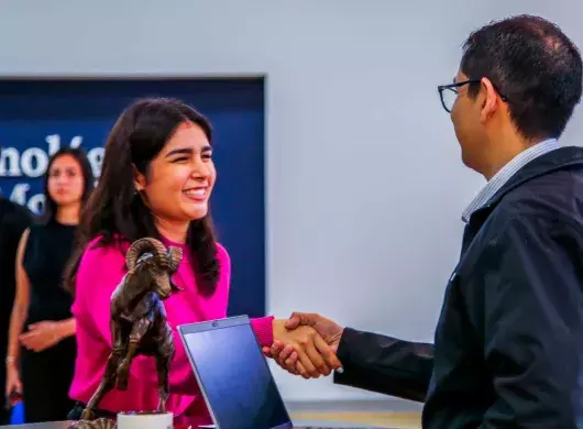 Candidata a graduar  de tec tampico saludando a un reclutadores