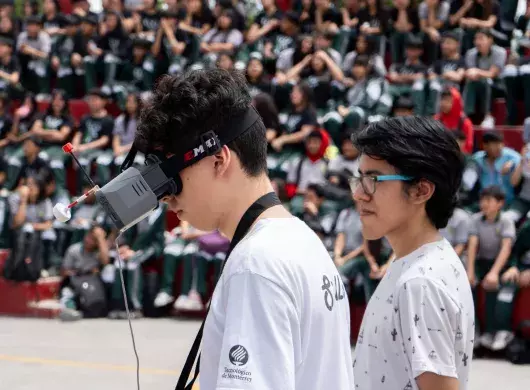 Miembros de DragonFly mostrando el uso de drones en Secundaria General #6