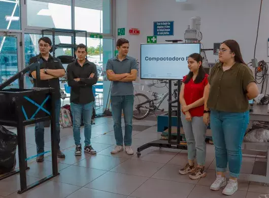 Estudiantes del Tec de Monterrey usando la compactadora de PET