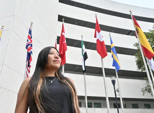 Mirian Ahuatzi posando frente a la bandera de Suiza, donde se encuentra el CERN