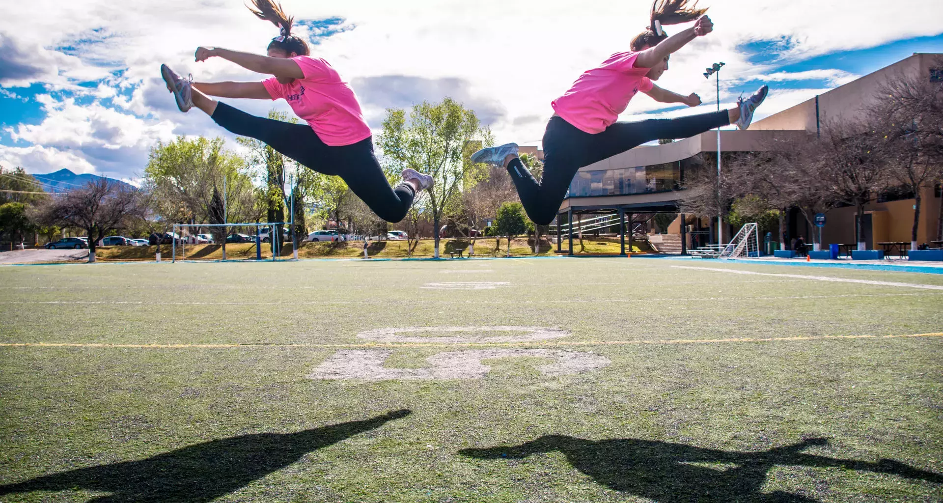 Dos mujeres haciendo acrobacias en una cancha de fútbol americano