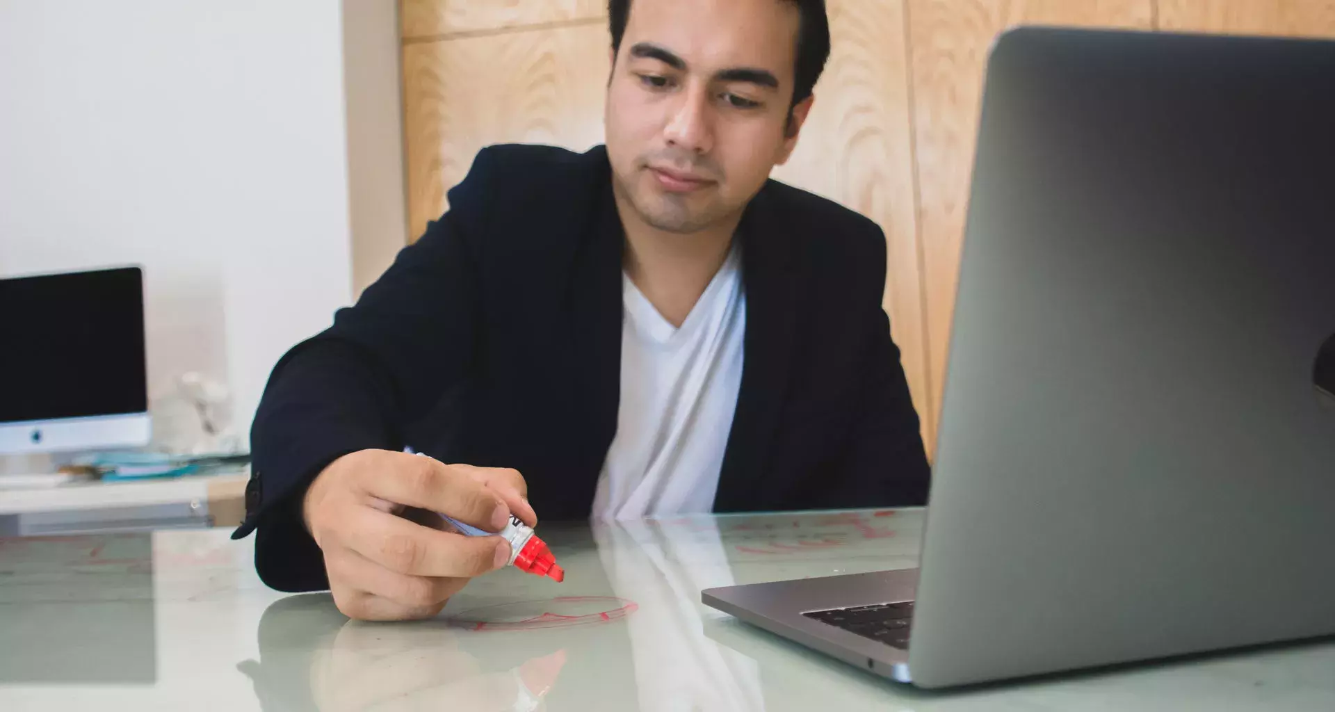 Jóven escribiendo en una mesa de vidrio