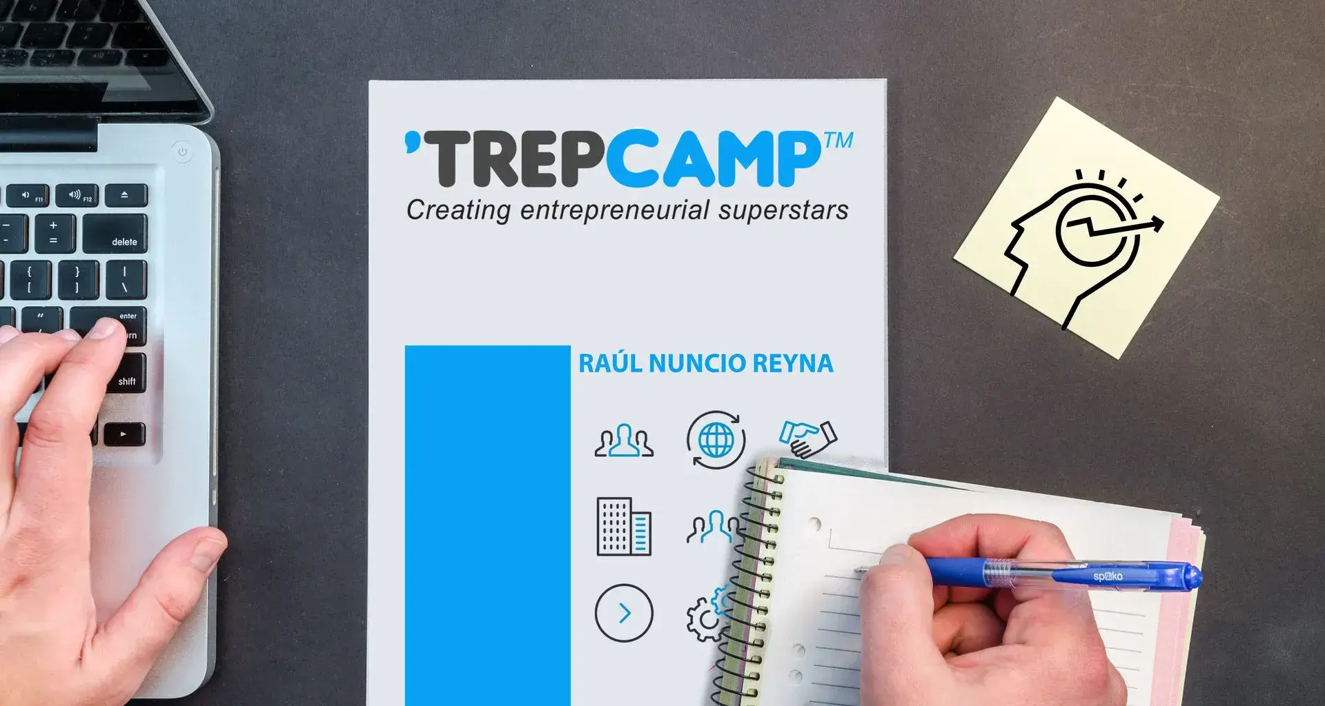 Escritorio con un cuaderno y una laptop. 