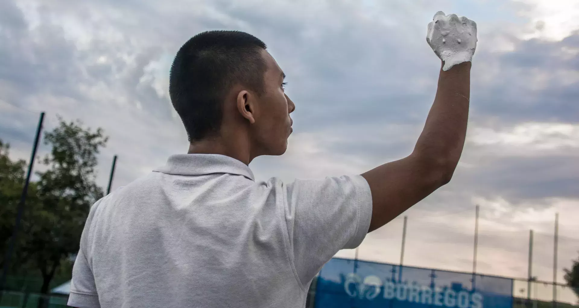 Alumno alzando su mano pintada en blanco