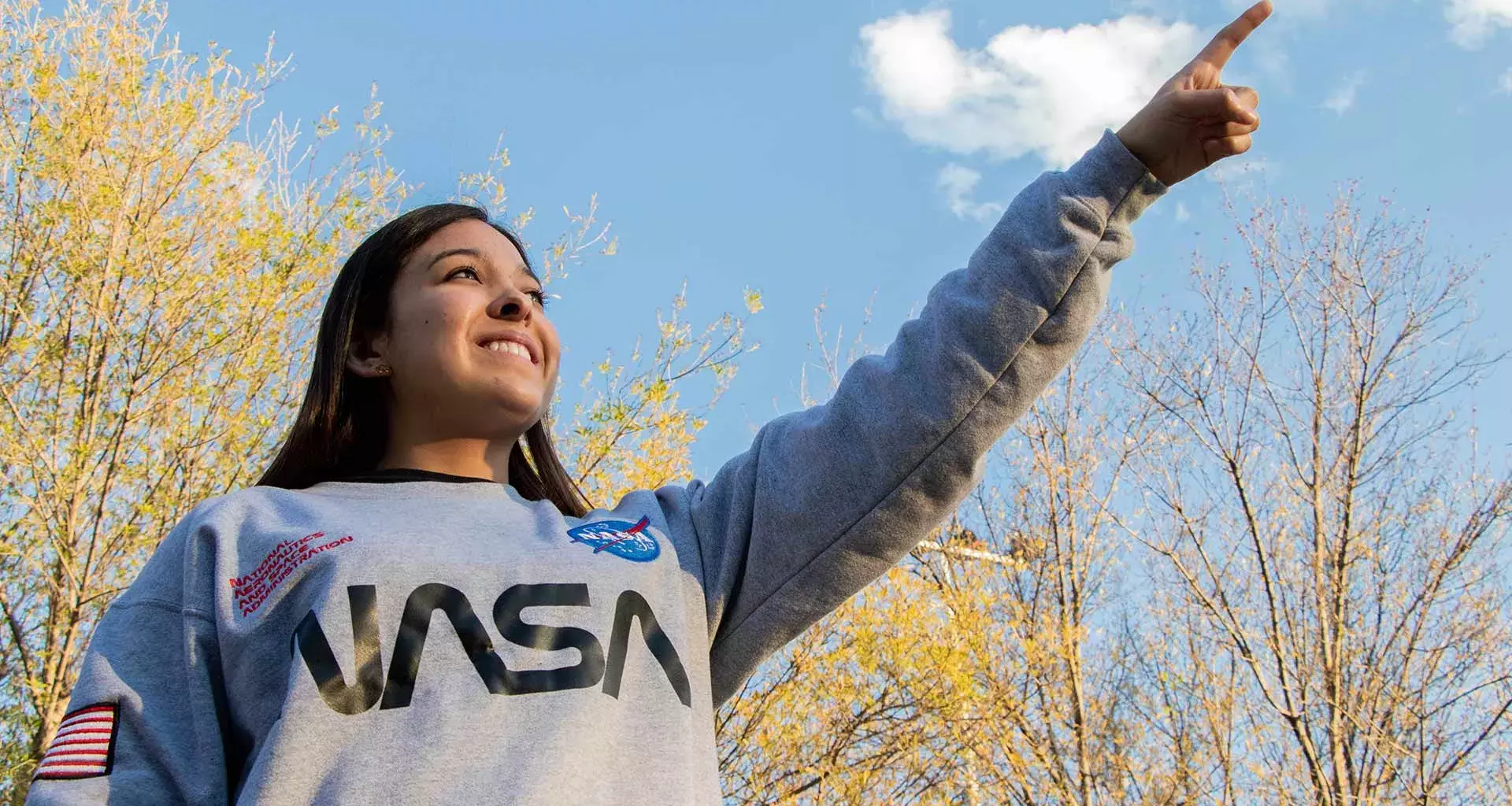 Carolina señalando el cielo con una sudadera de la nasa