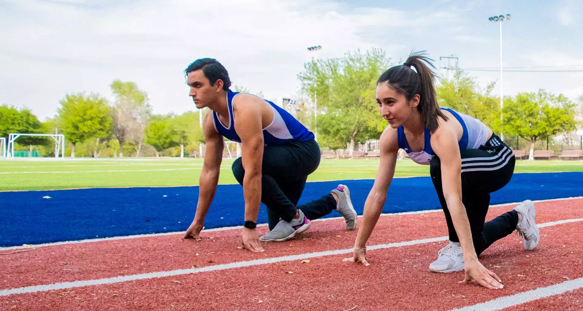 Sofia y Carlos en posición de marcas en la pista de atletismo