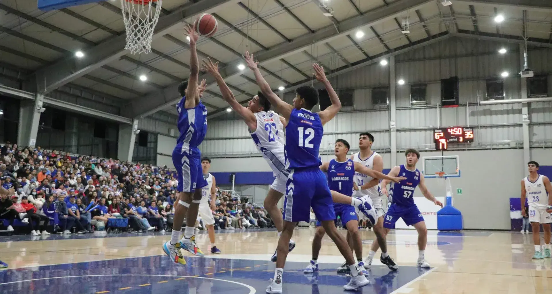 Ricardo Maciel, jugador de Borregos Hidalgo realizando una colada en medio de 2 jugadores.
