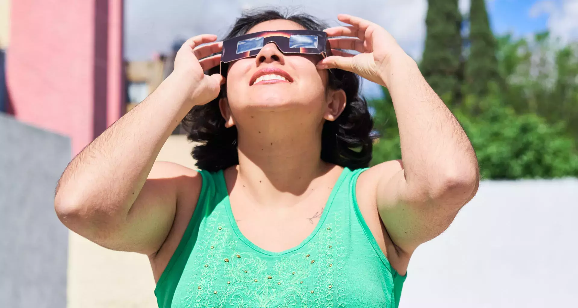 Mujer observa eclipse solar con lentes especiales.