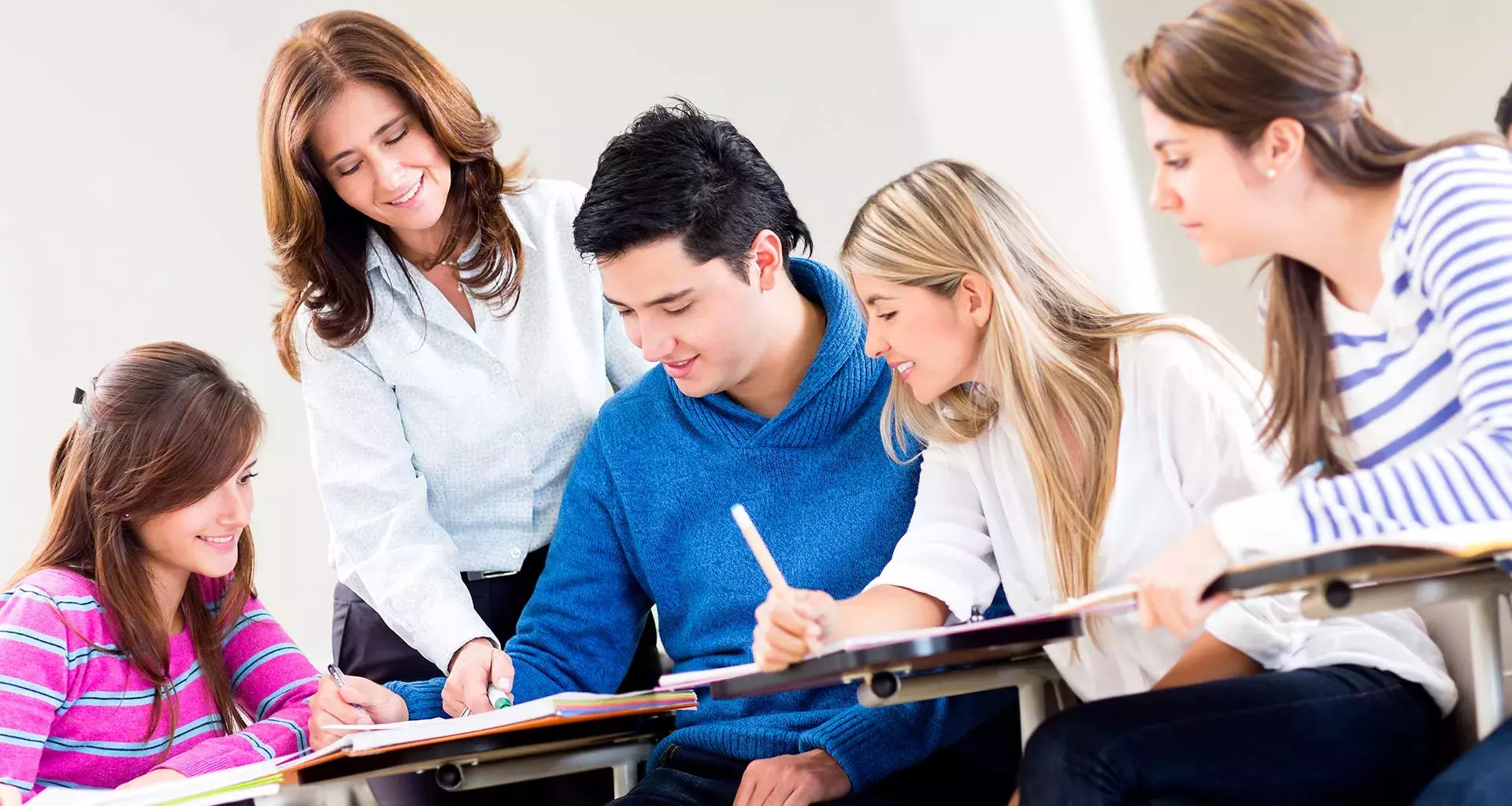 Profesora interactuando con un grupo de 4 alumnos