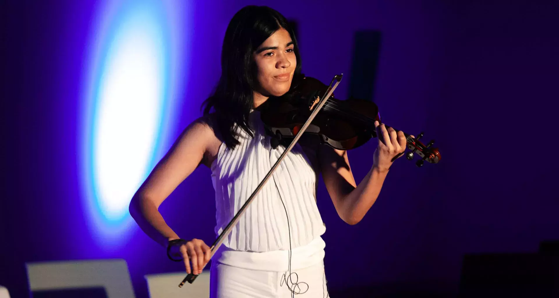 Estudiante del Tec de Monterrey vestida en blanco muestra su talento con la música tocando el violín