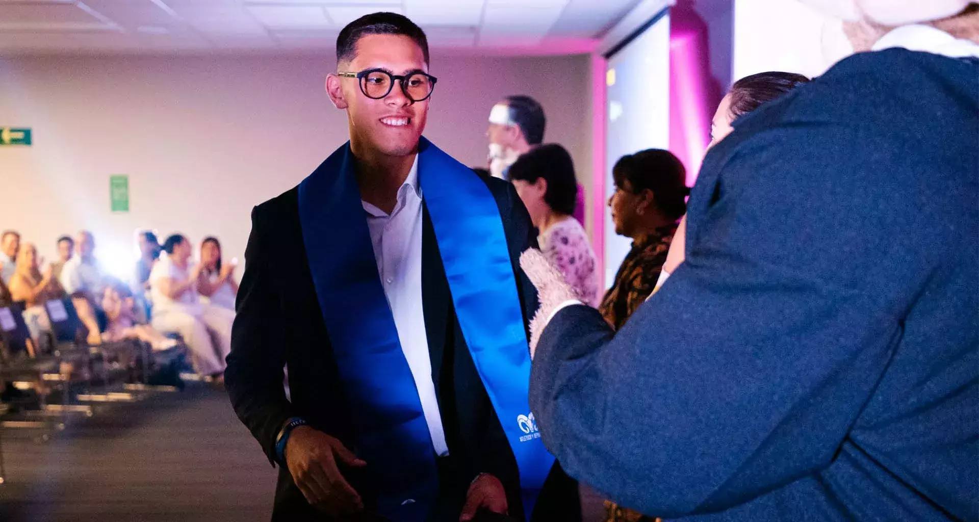 Estudiante de nivel preparatoria porta estola de graduación color azul con el logotipo de Borregos del Tec de Monterrey