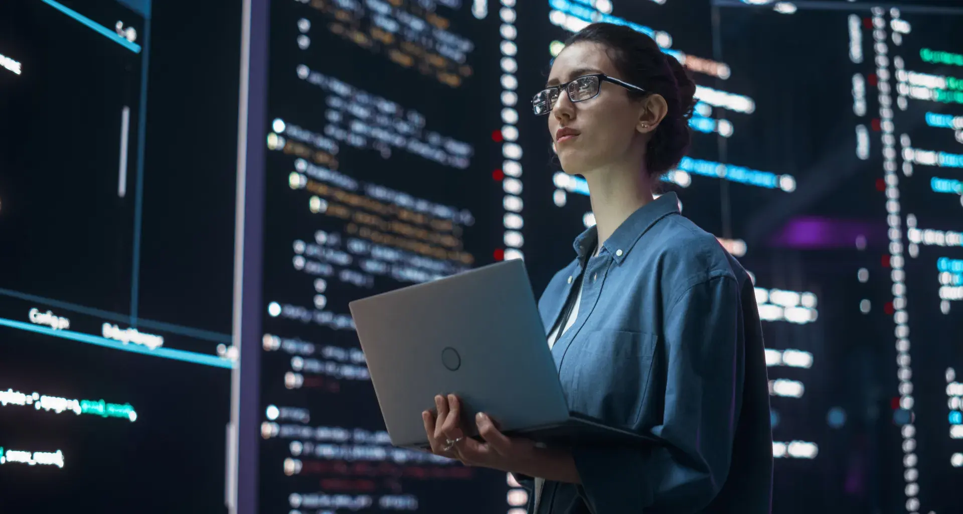 mujer con laptop viendo pantallas