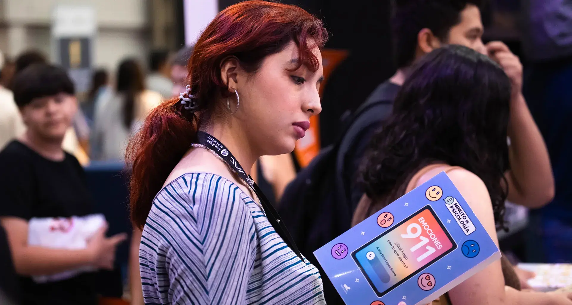 Mujer joven sosteniendo un libro durante la Feria Internacional del Libro Monterrey