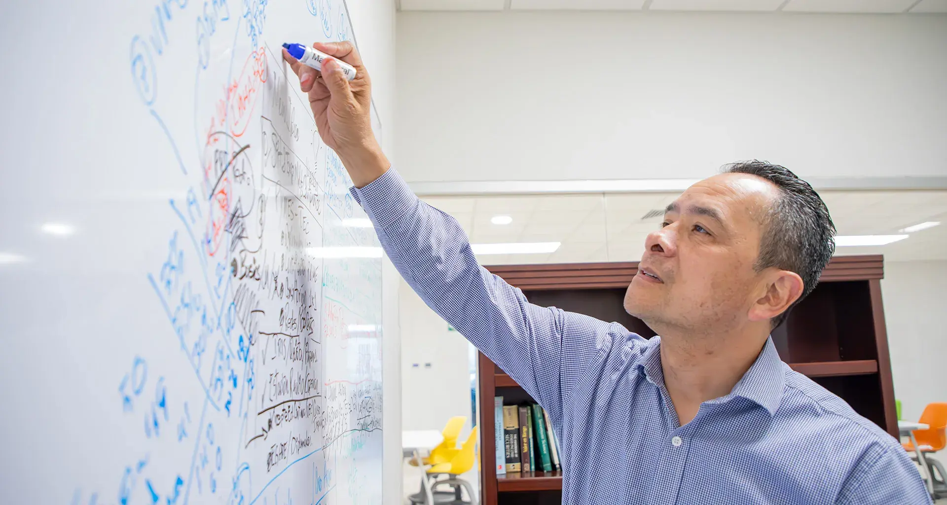 Profesor de la Escuela de Negocios del Tec de Monterrey campus Laguna utiliza pintarrón para hacer apuntes