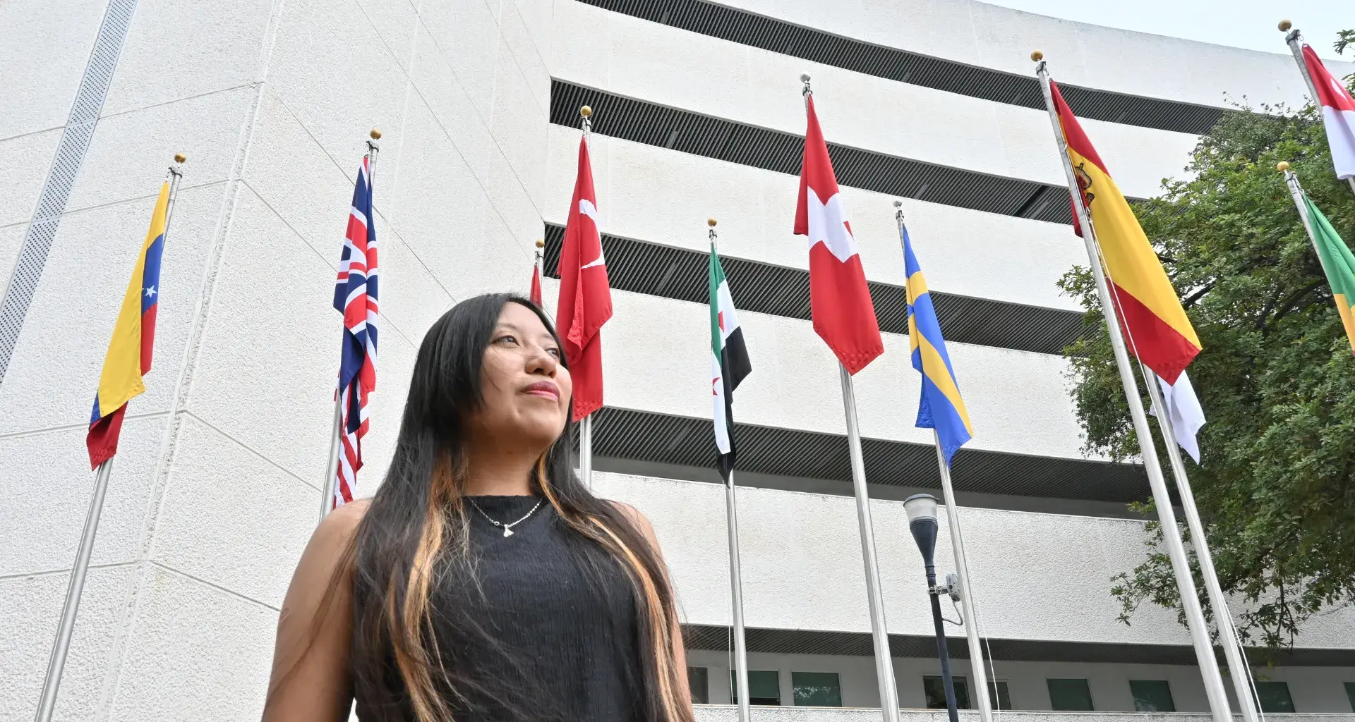 Mirian Ahuatzi posando frente a la bandera de Suiza, donde se encuentra el CERN