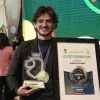 El alumno Marcelo Galán sostiene su premio en la categoría de Participación Social.