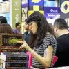 Una mujer leyendo "Los grandes iniciados" durante la Feria Internacional del Libro 2022.