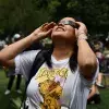 Colaboradora del Tec viendo el eclipse solar desde el Jardín de las Carreras.