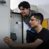 Dos estudiantes analizan los circuitos de una caja.