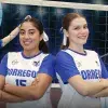 Dos jugadoras de voleibol paradas hombro a hombro con los brazos curazos y uniformes blancos que dicen BORREGOS en letra azul. En el fondo se ven imágenes de ellas jugando. 