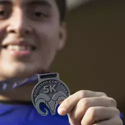 Reciben participantes medalla al finalizar la carrera.