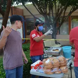 Alumnos del Reto promoviendo las hamburguesas de su sistema de negocios