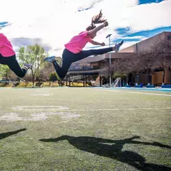 Dos mujeres haciendo acrobacias en una cancha de fútbol americano