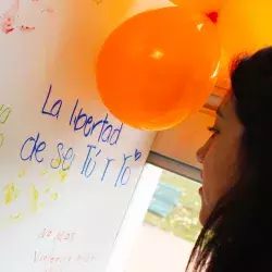 Mujer frente a un mural del Orange Day