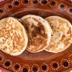 Foto de gorditas de azúcar en un plato de barro sobre una mesa