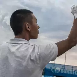 Alumno alzando su mano pintada en blanco