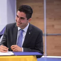 Estudiante Raul Maya de la carrera de Ingeniería Industrial firmando su título. 