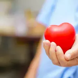 Manos de un médico sosteniendo una figura de corazón para representar la solidaridad en tiempos de COVID-19