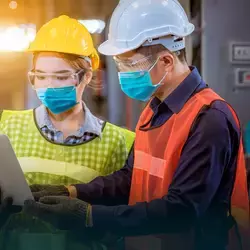 Foto empleados trabajando en fábrica con cubrebocas