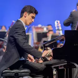 joven sentado tocando un piano