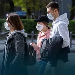 Foto de personas caminando por la calle con tapabocas