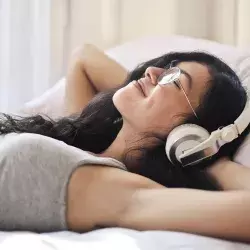 Joven acostada escuchando música