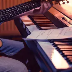 hombre-tocando-guitarra-junto-a-un-teclado