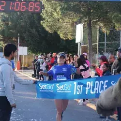 Corredora pasando meta con cinta de primer lugar femenil