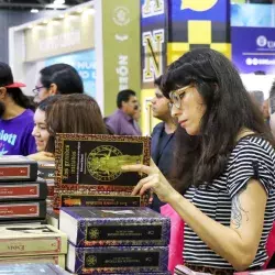 Una mujer leyendo "Los grandes iniciados" durante la Feria Internacional del Libro 2022.