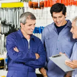 Tres generaciones de hombres platicando en una ferretería, concepto de una empresa familiar