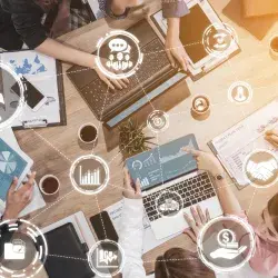 Equipo de emprendedores colaborando en una mesa con laptops, gráficas y herramientas digitales, analizando ideas de negocio y crecimiento