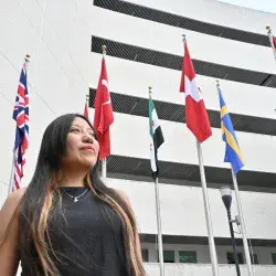 Mirian Ahuatzi posando frente a la bandera de Suiza, donde se encuentra el CERN