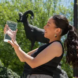 Alumna sosteniendo premio por adaptar maquinaria industrial