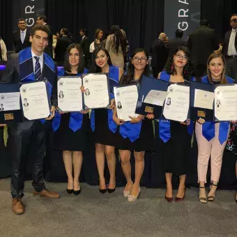 alumnos posando con su título