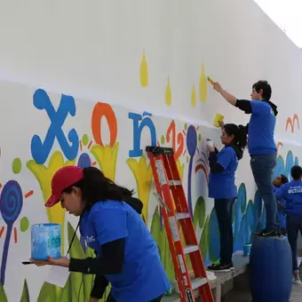 Trabajando en equipo para pintar el mural de la escuela 