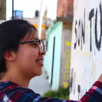 Alumnos y Armando Alanís pintando paredes con frases poéticas