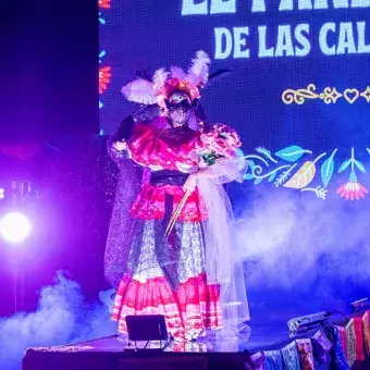 Una catrina con vestuario rosa desfila por la pasarela